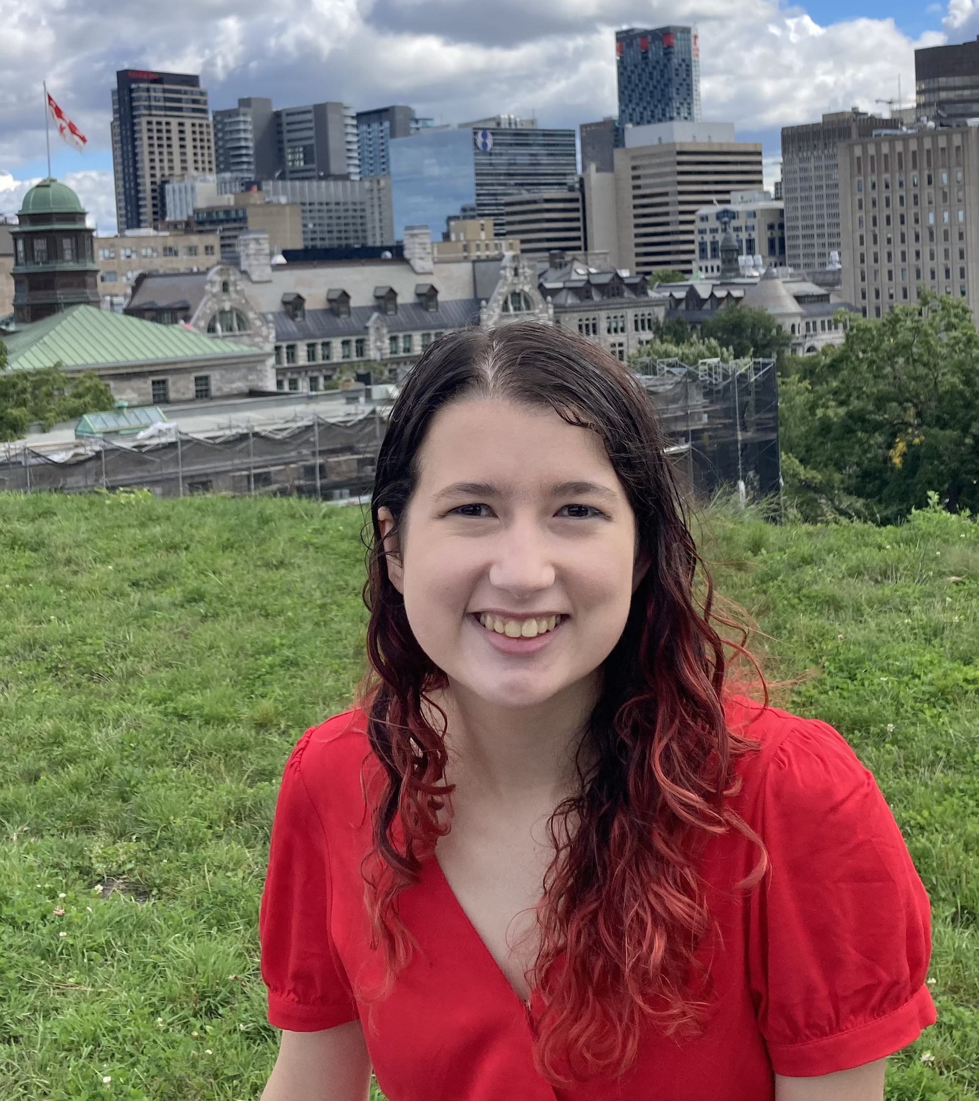 Portrait of Audrey sitting on a grassy hill overlooking McGill's campus